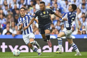 Mbappe Magic: 10-Man Real Madrid Squeaks Past Real Sociedad in La Liga Thriller
OR
La Liga: Mbappe Shines as Real Madrid Defeats Real Sociedad Despite Red Card Drama
OR
Real Madrid Overcomes Red Card, Edges Real Sociedad Thanks to Mbappe's Brilliance